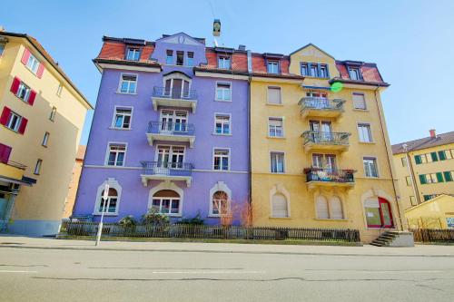 a purple building on the side of a street at HITrental Oerlikon Apartments in Zürich