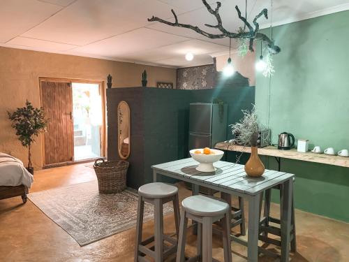 a kitchen with a table and stools in a room at Lush in Graskop