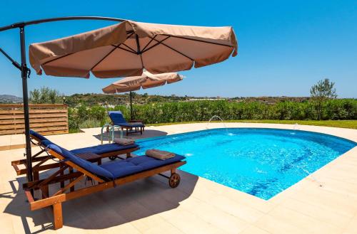a chair and an umbrella next to a swimming pool at Kolymbia Village in Kolimbia