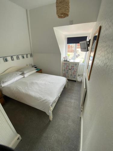 a small bedroom with a bed and a window at The Sandhaven in Swanage
