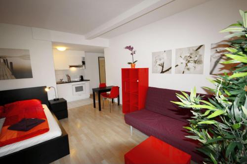 ein Wohnzimmer mit einem roten Sofa und einem Tisch in der Unterkunft HITrental Stauffacher Apartments in Zürich