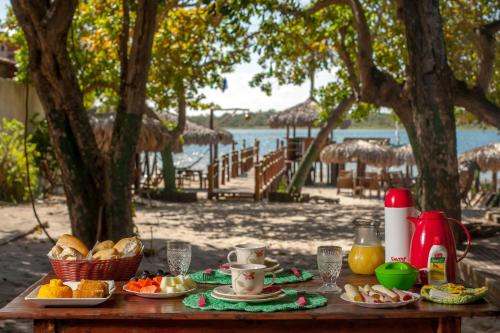 a table with plates of food and drinks on it at Pousada Flambaião in Jijoca de Jericoacoara