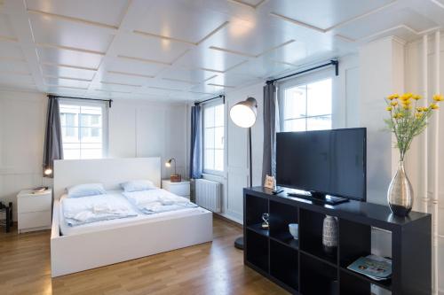 una camera con letto e TV a schermo piatto di HITrental Zeughausgasse - Apartment a Zugo