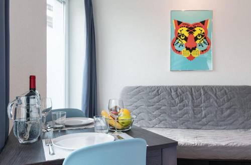 uma sala de estar com um sofá e uma mesa com copos de vinho em HITrental Altstetten Apartments em Zurique