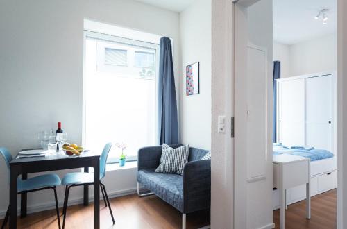 a living room with a table and a chair at HITrental Altstetten Apartments in Zürich