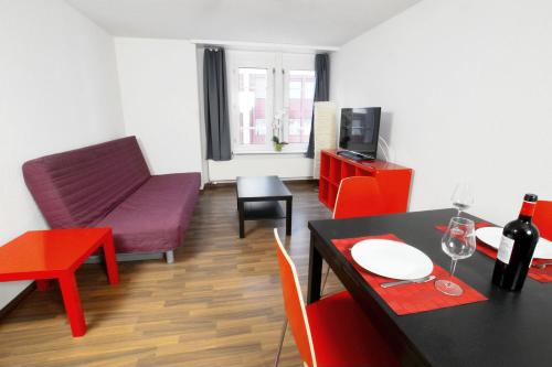 a living room with a table and a living room with a couch at HITrental Oerlikon Apartments in Zürich