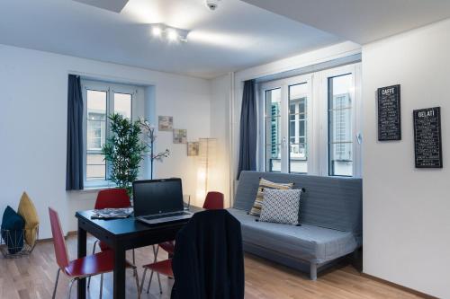 - un salon avec un canapé et une table avec un ordinateur portable dans l'établissement HITrental Old Town Apartments, à Lucerne