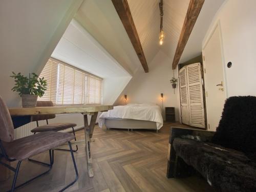een kamer met een bed, een tafel en een bank bij So Hum in Den Burg