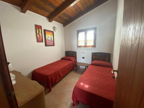 een slaapkamer met 2 bedden, een tafel en een raam bij B&B Le Stagioni in Castel del Monte