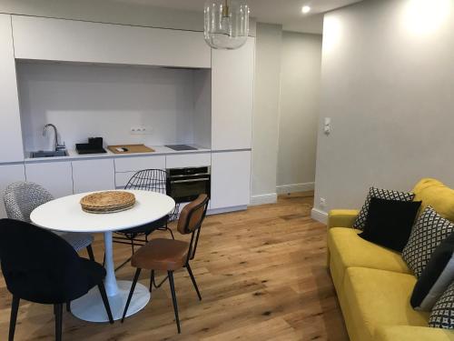 - un salon avec une table et un canapé jaune dans l'établissement Appartements de Standing - Panate, à Corte