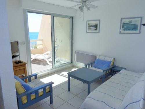 Cette chambre comprend un lit, des chaises et un balcon. dans l'établissement 54 M², DOUBLE TERRASSE, ASCENSEUR, PARKING, à Sète