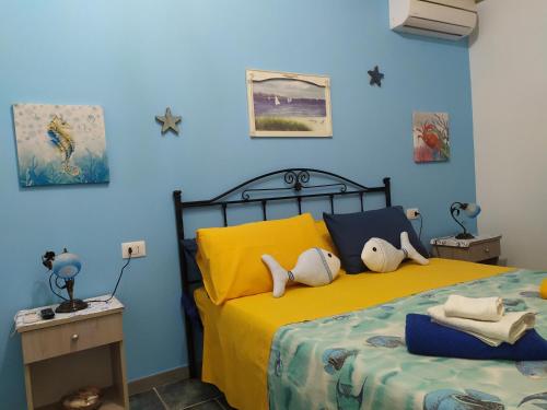 una camera da letto con un letto e pareti gialle e blu di I Ciusiddi a Portopalo