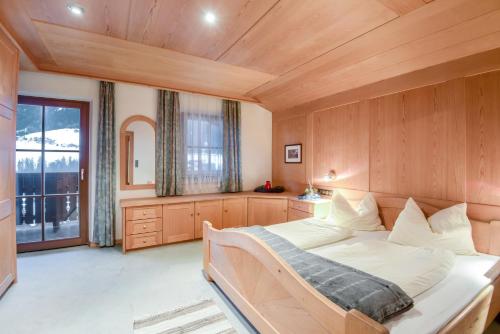 1 dormitorio con cama grande y ventana grande en Apartments Christa App A, en Ortisei