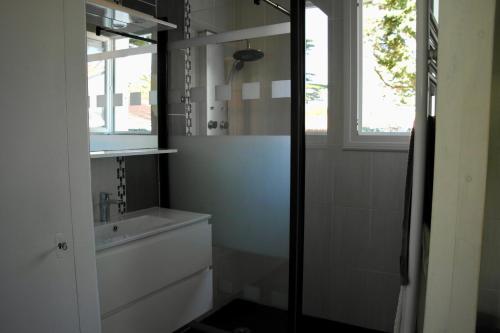 a bathroom with a sink and a toilet and a window at Charmante maison à 500 m de la côte, pour 4 in Notre-Dame-de-Monts