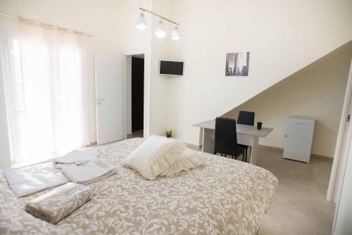 ein weißes Schlafzimmer mit einem Bett und einem Schreibtisch mit einem Computer in der Unterkunft Isola bella in Isola delle Femmine