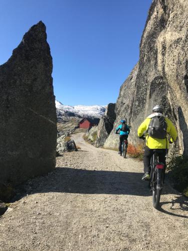 two people riding bikes on a dirt road at Vatnahalsen Høyfjellshotell in Myrdal
