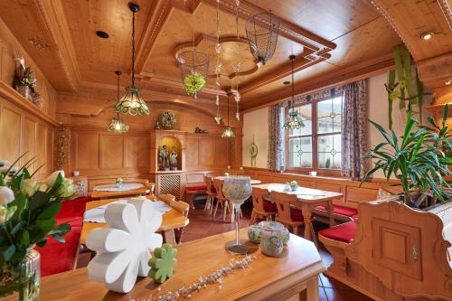 comedor con paredes de madera, mesas y sillas en Pension Zum Rechen, en Bodenmais