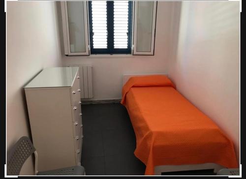 um pequeno quarto com uma cama, uma cómoda e uma janela em Riviera lanterna em Scoglitti