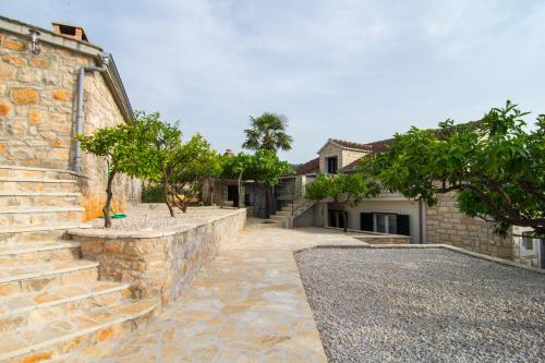 een stenen pad naar een huis met bomen bij Villa Sanja, Splitska in Splitska
