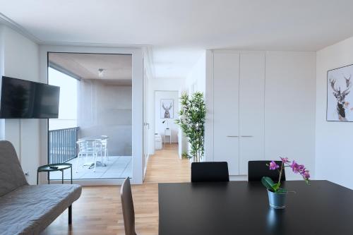 a living room with a table and a couch at HITrental Messe Apartments in Basel