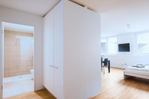 a bedroom with a white closet and a bathroom at HITrental Messe Apartments in Basel