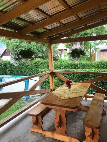 コシフにあるСадиба "Сонячна"の木製の柿の下の木製のピクニックテーブル