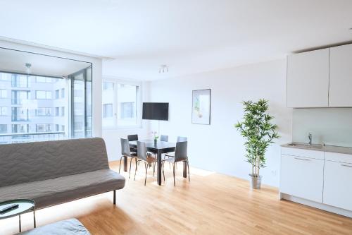 a living room with a couch and a table with chairs at HITrental Basel Apartments in Basel