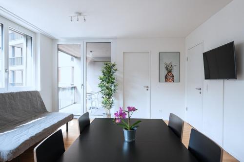 a living room with a table and a couch at HITrental Messe Apartments in Basel