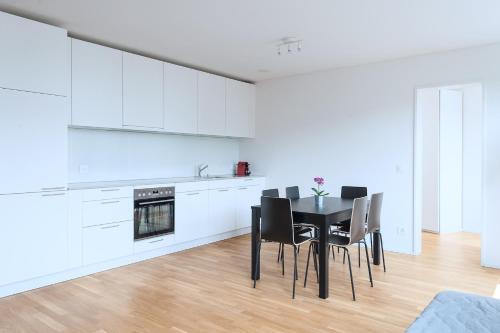 a dining room with a table and chairs in a kitchen at HITrental Messe Apartments in Basel