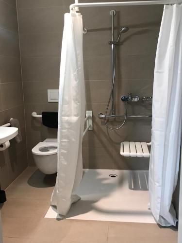 a bathroom with a shower with a toilet and a sink at HITrental Messe Apartments in Basel