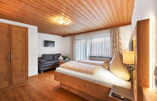 1 dormitorio con 1 cama con techo de madera en Pension Zum Rechen, en Bodenmais