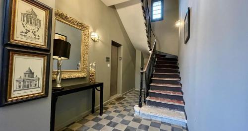 a hallway with a stairway with a mirror and a stair case at Quai du Félibre in LʼIsle-sur-la-Sorgue