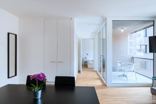 a living room with a table and a dining room at HITrental Messe Apartments in Basel
