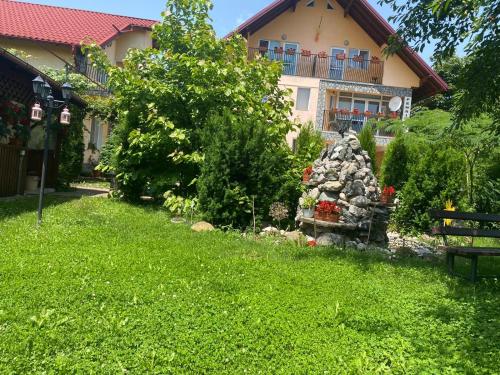 a garden in front of a house with a rock fountain at Villa Nina in Campina