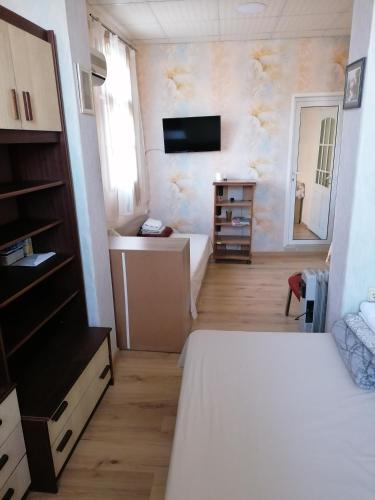 1 dormitorio con 1 cama y TV en la pared en КЪЩА ЗА ГОСТИ ОГИ en Montana