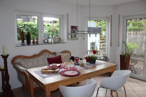 a dining room with a wooden table and chairs at Bed & Breakfast Bodensee mit Herz in Stockach