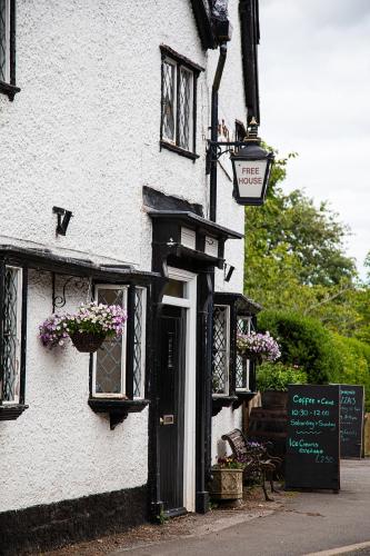 a white building with a door and flowers on it at The Yew Tree Inn in Church Stretton