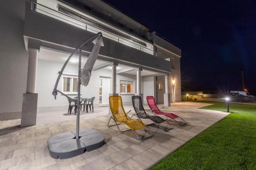 a group of chairs sitting on a patio at night at Apartments Luka in Senj