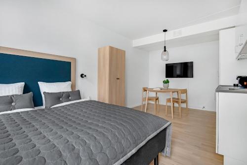a bedroom with a large bed and a table at STUDIO1A Hotel Apartments in Copenhagen
