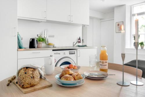 哥本哈根的住宿－STUDIO1A Hotel Apartments，一张桌子,上面放着一面包和一瓶橙汁