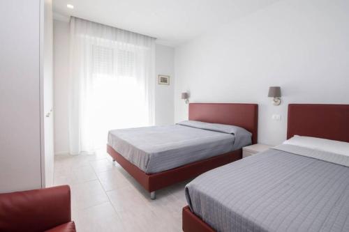 1 Schlafzimmer mit 2 Betten und einem Fenster in der Unterkunft Casa Plauto con appartamento grande in Bellaria-Igea Marina