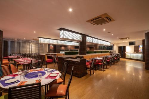 a restaurant with tables and chairs and a bar at Triose Boutique Hotel Lonavala in Lonavala