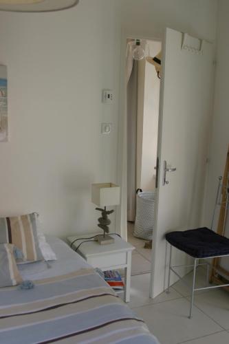 une chambre avec un lit, une table et une chaise dans l'établissement Villa traditionnelle pour 8 - 550m de la plage, à Noirmoutier-en-l'lle