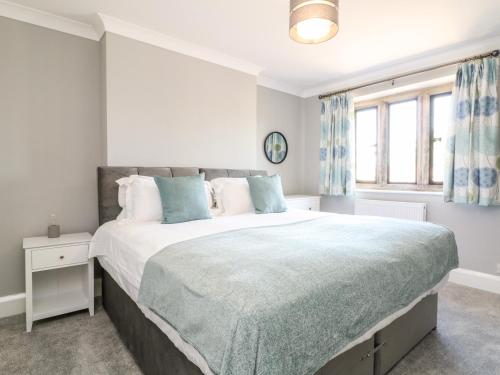 a bedroom with a large bed and a window at Well Cottage in Cheltenham