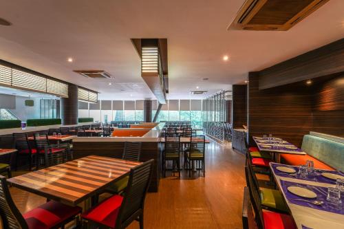 a restaurant with wooden tables and chairs and a dining room at Triose Boutique Hotel Lonavala in Lonavala