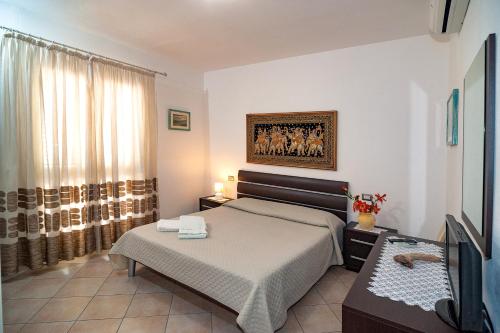 a bedroom with a bed and a television in it at Le Dune in San Teodoro