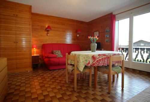 une salle à manger avec une table et une chaise rouge dans l'établissement PE255 Studio 4 pers pieds de piste, aux Carroz d'Arâches