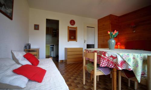 Cette chambre comprend une table, des chaises et des oreillers rouges. dans l'établissement PE255 Studio 4 pers pieds de piste, aux Carroz d'Arâches