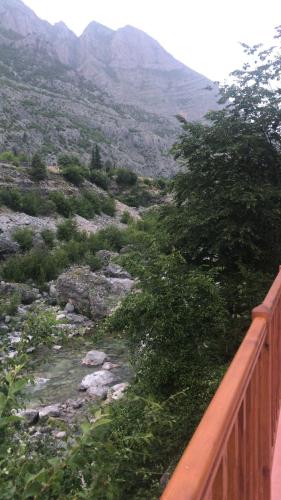 a view of a river with a fence and mountains at Sofra Kelmendit in Tamarë