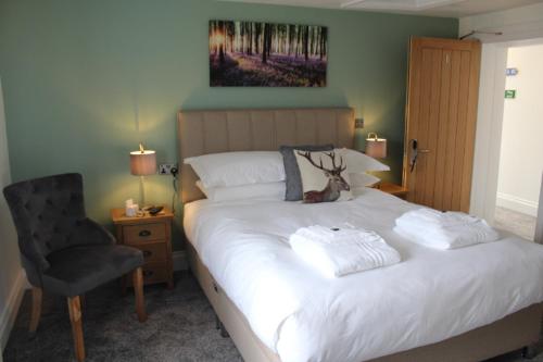 a bedroom with a large white bed with a chair at The White Lion in Ventnor